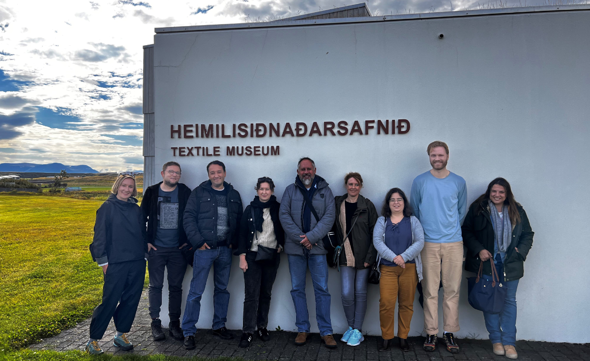 Zespół ALLURE (5 kobiet i 4 mężczyzn z Islandii, Polski, Portugalii i Hiszpanii) na ścianie frontowej Muzeum Włókiennictwa w Blönduós, Islandia.